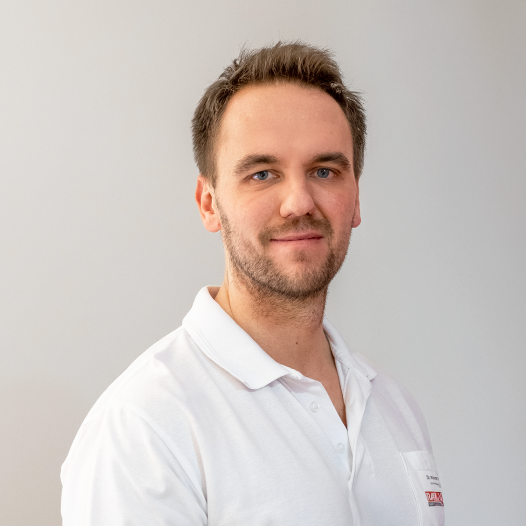 MUDr. Petr Vosátka, ein Arzt mit kurzen braunen Haaren und hellem Bart, steht vor einem hellen Hintergrund in einem weißen Hemd und blickt in die Kamera. Das Porträt ist auf der Website von RADIO-LOG zu sehen, einem Gesundheitsdienstleister in Bayern, der patientenzentrierte radiologische und medizinische Versorgung an mehreren Standorten anbietet.